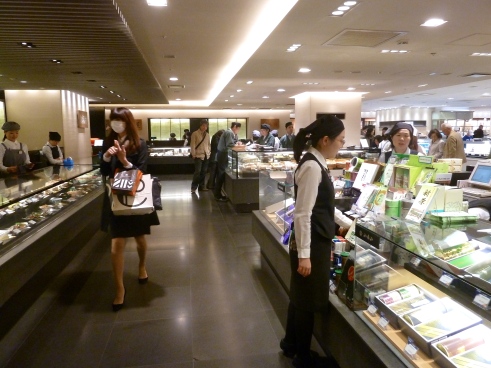 Isetan department store food halls.  See the woman walking on the left?  She is wearing a surgical face mask.  About 10% of the people you see have one on, both in offices and out on the street.  They are trying to prevent sickness, or in the case of someone who is already sick, they are protecting other people.
